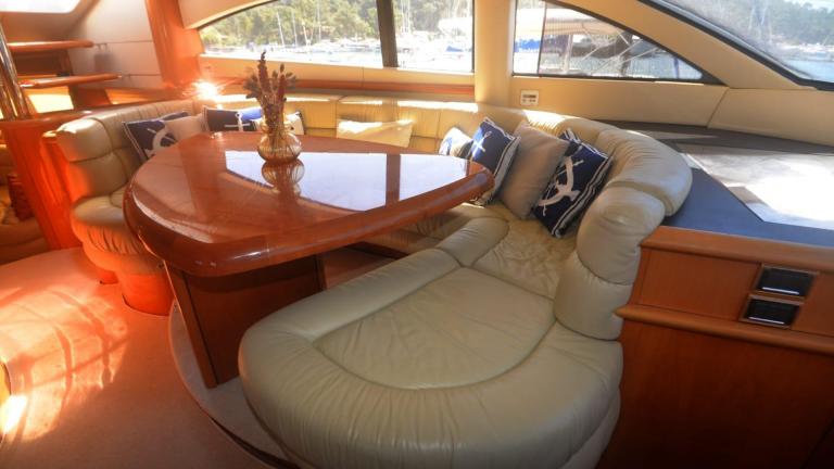A yacht cabin with a soft sofa and a table